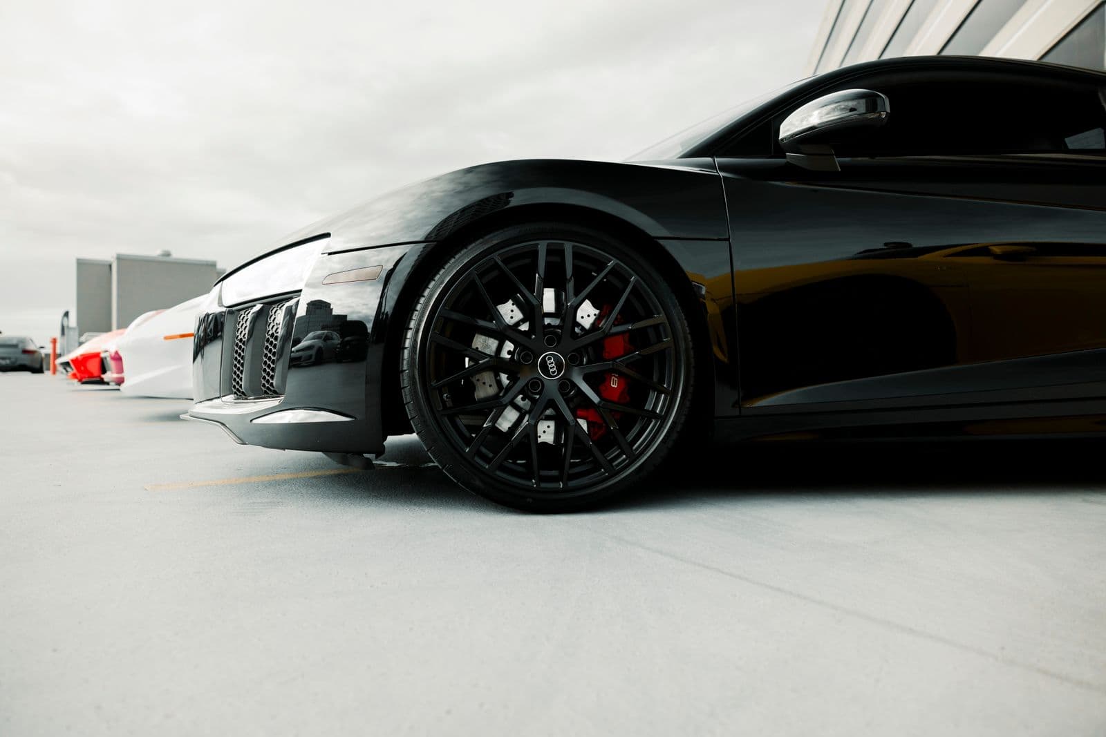 A sleek black luxury car parked under studio lighting